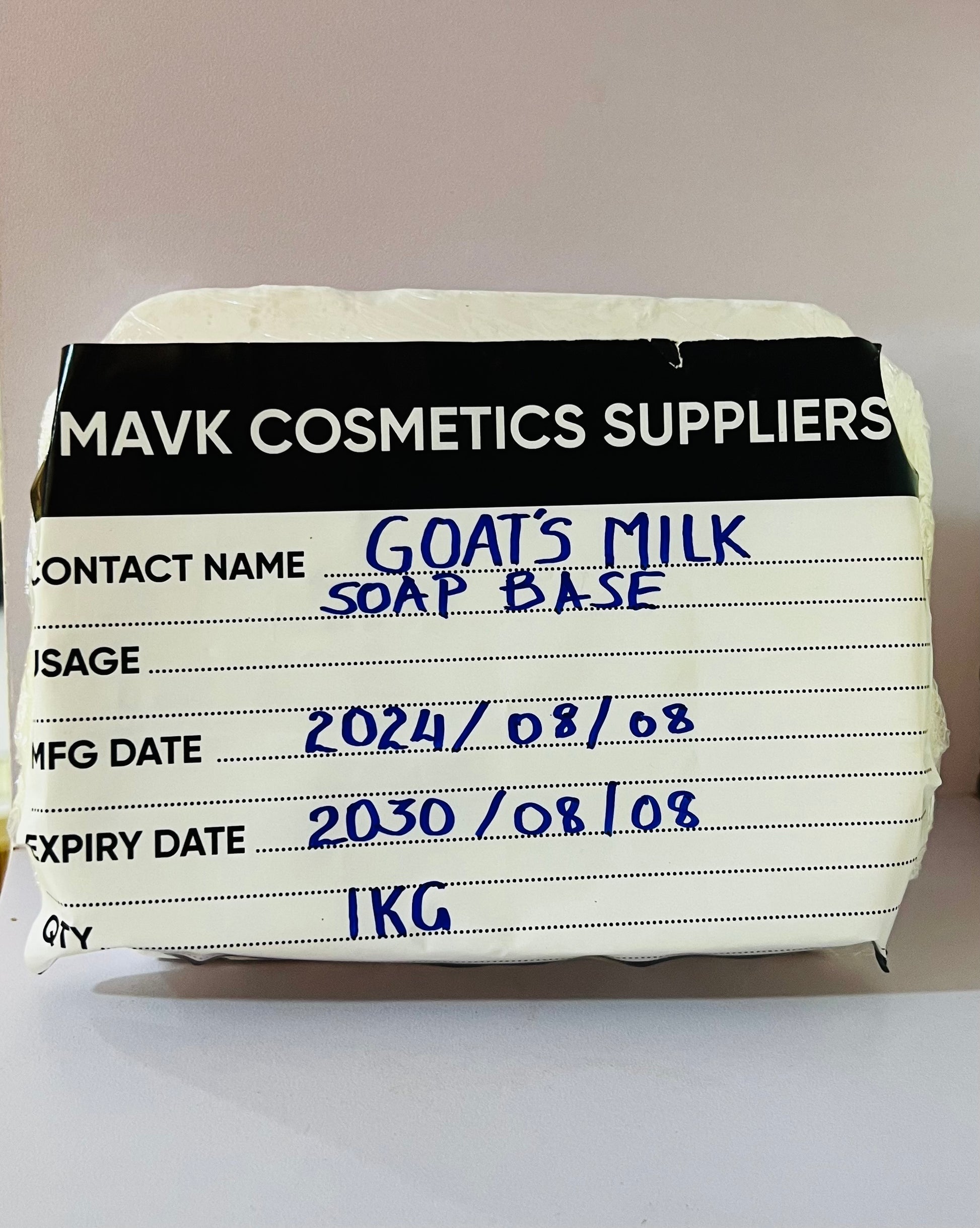 A packaged Goats Milk Soap Base from Mavk Cosmetics Suppliers, with labels indicating the brand, product name, contact name, weight of 1kg, and dates.